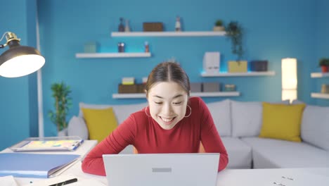 Beautiful-Asian-woman-jumping-with-joy,-happy-with-what-she-sees-on-the-screen-while-browsing-the-laptop.